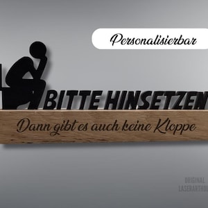 Könnte beinhalten: Ein Holzschild mit einer schwarzen Silhouette einer Person, die auf einer Toilette sitzt. Das Schild lautet "Bitte Hinsetzen Dann gibt es auch keine Kloppe". Das Schild ist personalisierbar und kann mit unterschiedlichem Text angepasst werden.