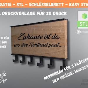 Puede incluir: Llavero de madera con ganchos negros y el texto "Zuhause ist da wo der Schlüssel passt...". El llavero es de madera y tiene un marco negro. La imagen también incluye el texto "STL Druckvorlage für 3D Druck".
