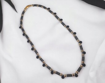 atemberaubende schwarze Heishi und Gold Halskette mit schwarzem Charme Detail