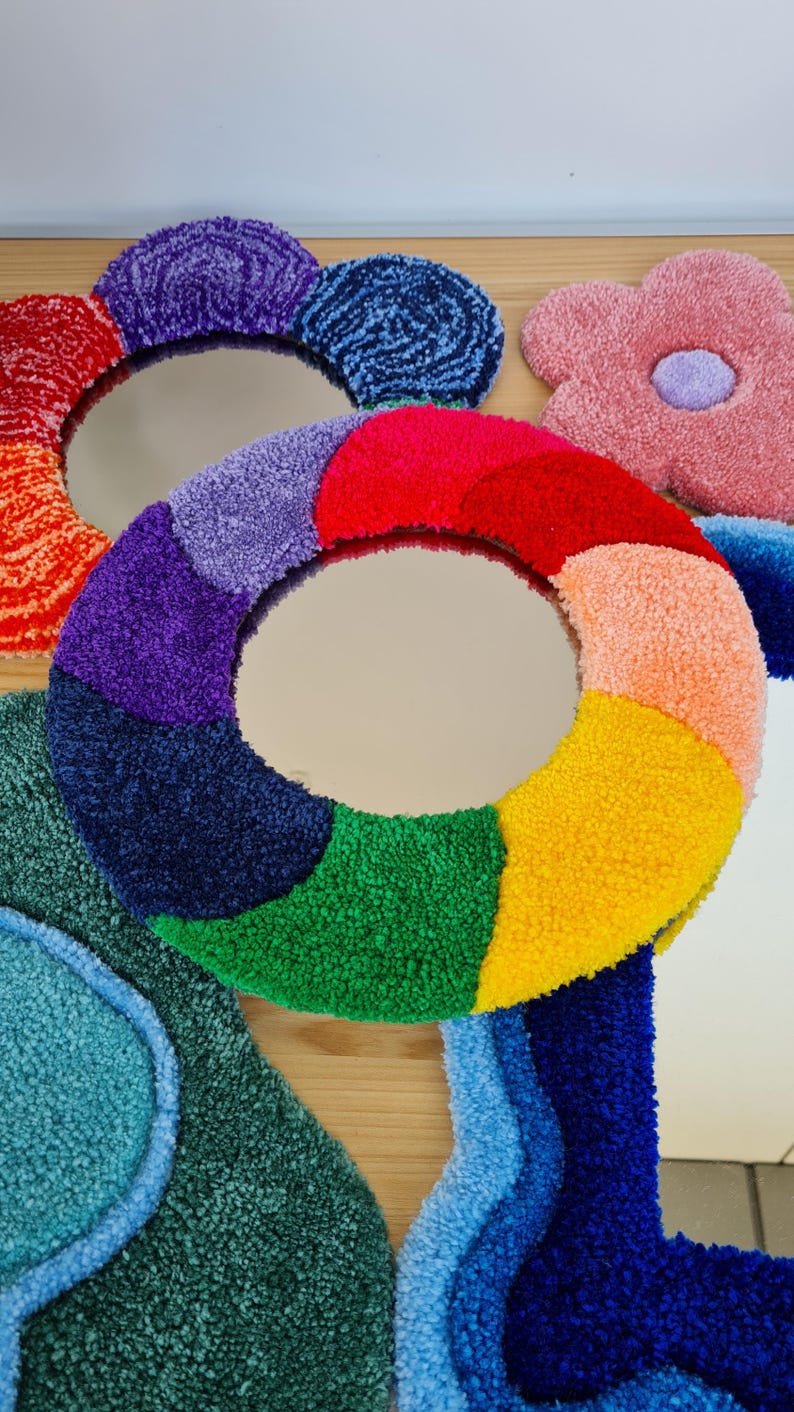May include: A colorful, round mirror with a rainbow design. The mirror is surrounded by a variety of other colorful, fluffy shapes.