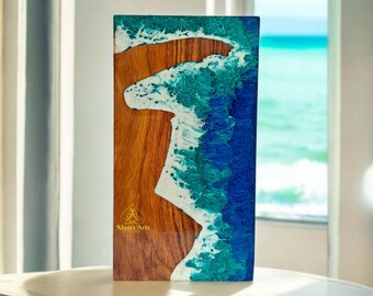 May include: A rectangular wooden panel with a blue, green and white resin wave design. The panel has a wood grain texture and the text "Alam's Arts" is visible in the bottom right corner.