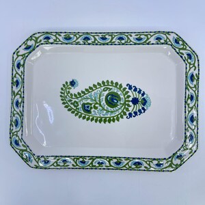 May include: A rectangular white ceramic serving tray with beveled corners. The rim features a continuous green and blue floral vine pattern. The center of the tray displays a large, detailed green and blue paisley motif with intricate details.