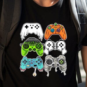 May include: A black t-shirt with a graphic of five different video game controllers in Halloween costumes. The controllers are dressed as a ghost, a pumpkin, a monster, a skeleton, and a mummy.