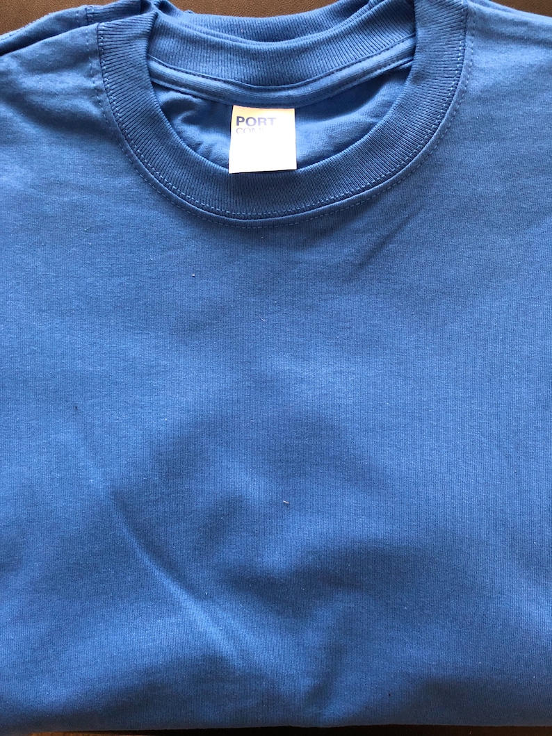 May include: A folded blue t-shirt with a white tag that says "PORT & CO."