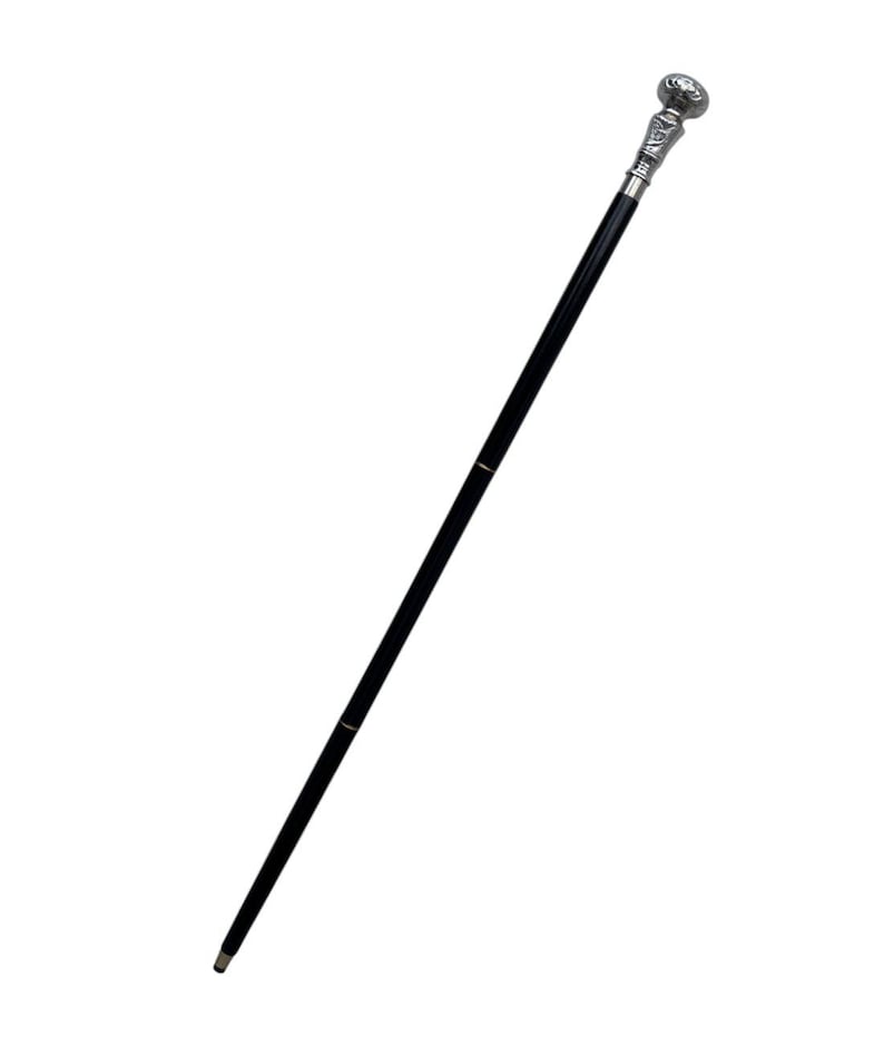 May include: A black walking cane with a decorative silver-colored handle. The handle has a detailed design, and the cane has a sleek, polished appearance. The cane is a classic accessory.