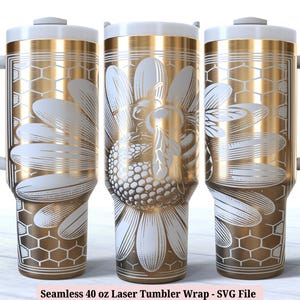 Peut inclure: Un gobelet de 40 onces de couleur or et blanc avec un motif de marguerite et d'abeille. Le gobelet est doté d'un couvercle et d'une poignée.  Modèle de gobelet laser sans couture de 40 oz - Fichier SVG