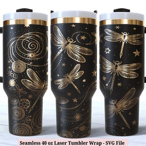 May include: A black and gold 40 ounce tumbler with a dragonfly design. The tumbler has a black handle and a gold lid. The design includes a repeating pattern of dragonflies, stars, and swirls.