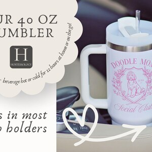 May include: White 40 oz tumbler with a handle, featuring a pink "Doodle Mom Social Club" design. The tumbler has a white lid and a straw. The text on the image says "Our 40 oz Tumbler" and "fits in most cup holders".