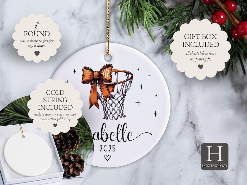 May include: White ceramic basketball ornament, 3 inches in diameter, with a basketball hoop design and an orange bow. Includes a gold string for hanging. Features the name "Abelle" and the year 2025.