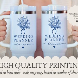 Puede incluir: Dos tazas aisladas blancas con un dise&ntilde;o floral azul y el texto "WEDDING PLANNER" y un nombre. Las tazas tienen asas y tapas blancas. Tambi&eacute;n es visible el texto "HIGH QUALITY PRINTING".