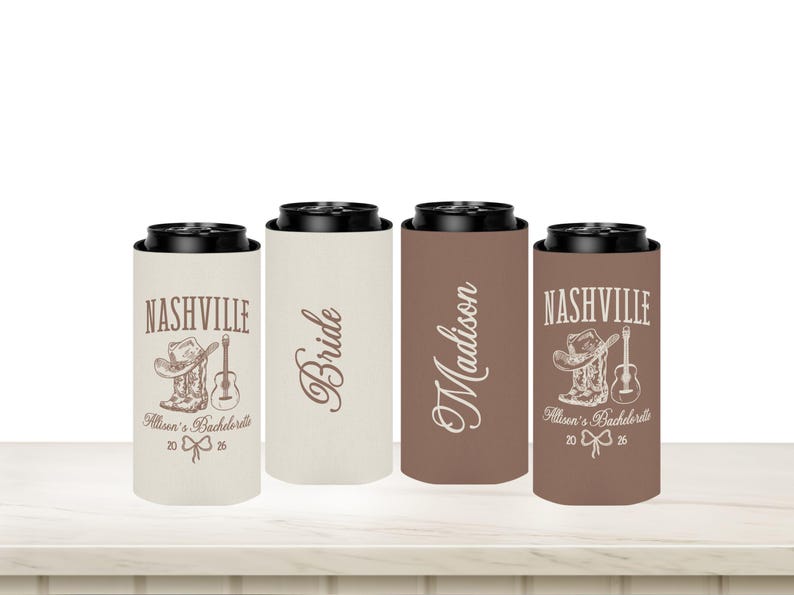May include: Four slim can coolers with black tops. Two are tan, one is brown, and one is a darker brown. Text includes "Nashville", "Bride", and "Madison". The Nashville coolers have a cowboy boot, hat, and guitar graphic.