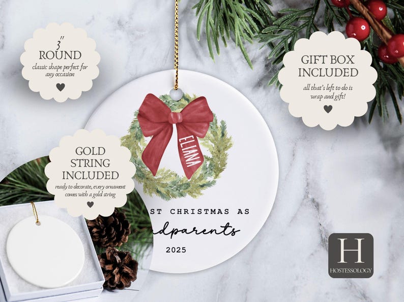 May include: A 3-inch round white ceramic ornament featuring a watercolor green wreath with a red bow and the name ELIANA printed on the ribbon. The text reads FIRST CHRISTMAS AS grandparents 2025. It includes a gold string and a gift box.
