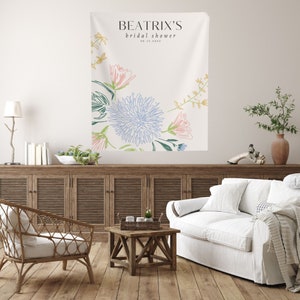 May include: A white bridal shower banner with the text "Beatrix's bridal shower 06.17.20XX" and a floral design featuring blue, pink, and green flowers.