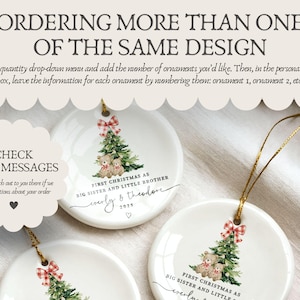 May include: White ceramic Christmas ornaments with a gold string for hanging. Each ornament features a Christmas tree with teddy bears and a red and white plaid bow. Text reads "First Christmas as Big Sister and Little Brother" with names and the year.