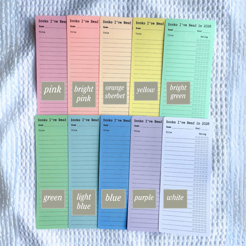 May include: A collection of colorful bookmarks with the text "Books I've Read" and "Books I've Read in 2026". The bookmarks are in various colors, including pink, bright pink, orange sherbet, yellow, bright green, green, light blue, blue, purple, and white.
