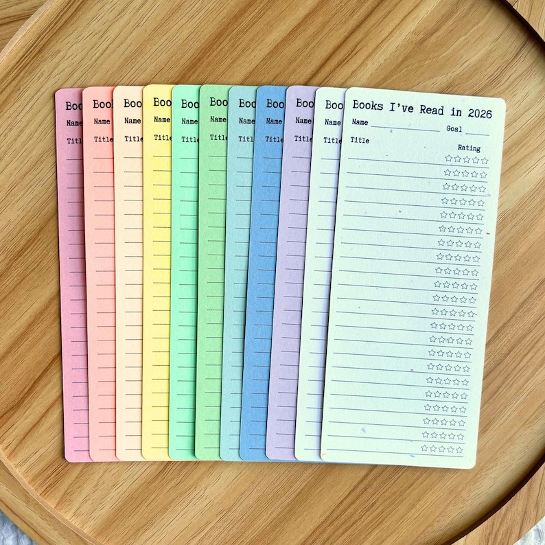 May include: A collection of colorful book trackers. Each tracker is a different pastel color, with lines for the book title, name, and rating. The text "Books I've Read in 2026" is printed on one of the trackers.