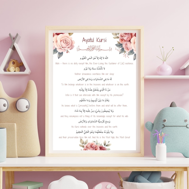 May include: A printable wall art design featuring a pink floral border and the Arabic text of Ayatul Kursi, a verse from the Quran. The text is translated into English below the Arabic script.