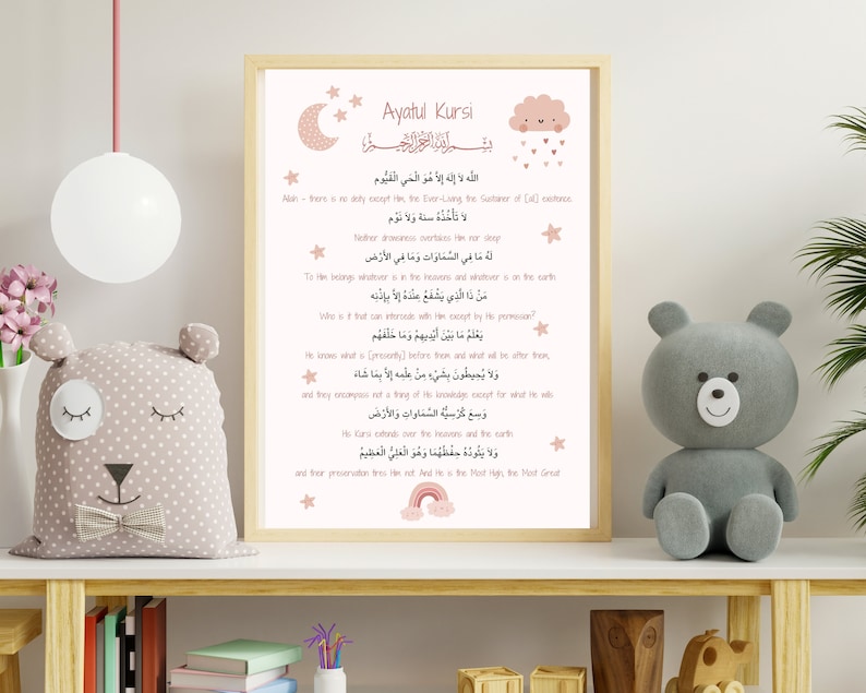May include: A pink and white printable wall art print with the Arabic text of Ayatul Kursi, a verse from the Quran. The print features a crescent moon, a cloud with raindrops, and a rainbow.