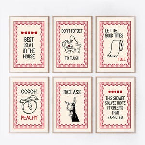 Peut inclure: Six tableaux encadrés pour salle de bain, avec des textes humoristiques et des illustrations. Les impressions présentent des phrases comme « Meilleure place de la maison » et « Nice Ass », avec des images de toilettes et de fruits.