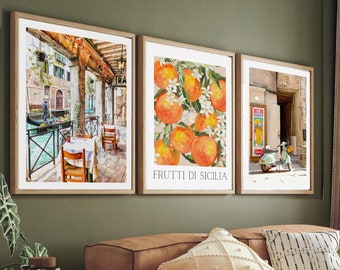 May include: A living room with a brown leather sectional sofa, three framed prints on the wall, and a wooden coffee table with a book and a cup on it. The prints feature a canal scene, a still life of oranges, and a scooter in a street scene. The sofa has a throw blanket and several pillows.