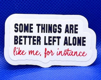 May include: A rectangular white sticker with a die-cut edge featuring the black text "SOME THINGS ARE BETTER LEFT ALONE" and the red cursive text "like me, for instance" printed on the front, centered against a solid blue background.