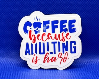 May include: A die-cut sticker with a white background featuring the blue text COFFEE and ADULTING in a bold sans-serif font, with the red script text because and is hard. A small blue coffee cup icon is integrated into the word COFFEE.