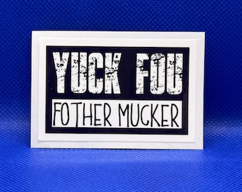 May include: A rectangular greeting card with a white border and a black center panel. The text YUCK FOU is printed in a distressed white font on the top half, and the text FOTHER MUCKER is printed in a clean white font on the bottom half.