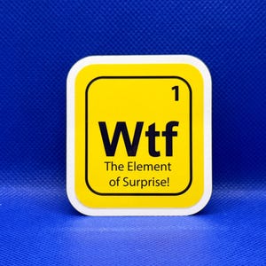 May include: A yellow and black square sticker with rounded corners. The sticker features the word "Wtf" in bold black letters, with the text "The Element of Surprise!" below. The background is a solid blue.