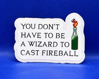 May include: A white rectangular sticker with rounded edges featuring the black text 'YOU DON'T HAVE TO BE A WIZARD TO CAST FIREBALL' and a graphic of a green glass bottle with a lit orange and red flame coming out of the top, set against a blue background.