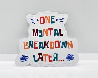 May include: White sticker with the text "One mental breakdown later..." in colorful, stylized lettering.