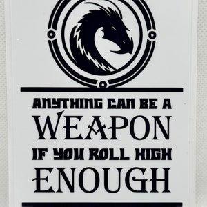 May include: Black and white sticker with a dragon in a circle and the text "Anything can be a weapon if you roll high enough".