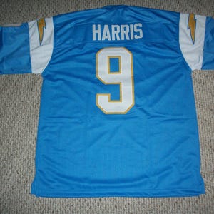 Puede incluir: Una camiseta de f&uacute;tbol azul claro con el nombre "HARRIS" y el n&uacute;mero "9" en blanco con ribete dorado. La camiseta tiene detalles en blanco y dorado en las mangas y un dise&ntilde;o de rayo.