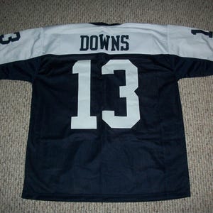 May include: A navy blue football jersey with white accents. The jersey features the name "DOWNS" across the shoulders and the number "13" in large white numerals on the front and back. The sleeves have the number "3" and "1" in white.