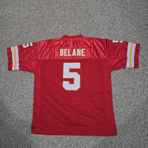 May include: Red football jersey with white and yellow accents. The jersey features the name "DELANE" across the upper back and the number "5" in white with a yellow outline. The sleeves have white and yellow stripes.