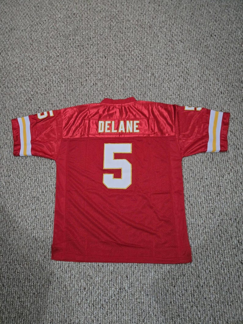May include: Red football jersey with white and yellow accents. The jersey features the name "DELANE" across the upper back and the number "5" in white with a yellow outline. The sleeves have white and yellow stripes.