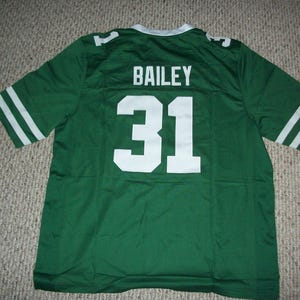 Peut inclure: Maillot de football vert avec des rayures blanches sur les manches et le numéro 31 à l'avant. Le nom "BAILEY" est imprimé au-dessus du numéro. Le maillot a un col blanc.