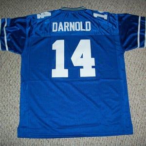 Könnte beinhalten: Blaues Footballtrikot mit weißen Buchstaben. Das Trikot trägt den Namen "DARNOLD" und die Nummer "14" auf der Rückseite.