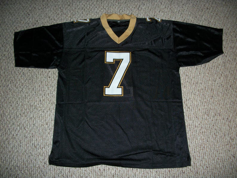 May include: Black football jersey with a white number "7" on the front. The jersey has gold trim around the neck and sleeves.