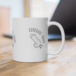 Può includere: Tazza in ceramica bianca con un'illustrazione in bianco e nero di un uccello con il testo "Schräger Vogel" sul lato.