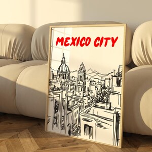 May include: A black and white sketch of the Mexico City skyline with the words "MEXICO CITY" in red at the top of the image. The sketch is framed and leaning against a beige couch.