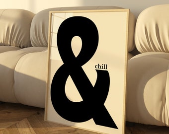 May include: A black and white framed print with a large black ampersand symbol and the word "chill" in black text. The print is hanging on a white wall above a beige sectional sofa.