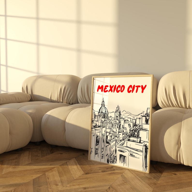 May include: A black and white sketch of the Mexico City skyline with the words "MEXICO CITY" in red at the top of the image. The sketch is framed and leaning against a beige couch.