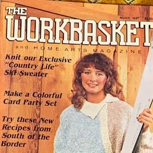 May include: A magazine cover for "The Workbasket" from March 1987. The cover shows a woman in a blue and beige knit sweater, holding a ski. Text includes "Knit our Exclusive 'Country Life' Ski Sweater" and "Home Arts Magazine."