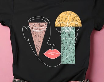 Puede incluir: Camiseta negra con un diseño gráfico de una cara estilizada con una flor y formas geométricas en rosa, amarillo, verde y azul.
