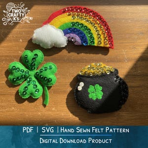 May include: Felt St. Patrick's Day decorations including a rainbow with sequins, a four-leaf clover, and a pot of gold. The rainbow is red, orange, yellow, green, blue, and purple. The clover and pot of gold have green clovers. The text says "PDF | SVG | Hand Sewn Felt Pattern".