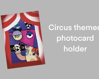 Peut inclure: Porte-cartes photo sur le thème du cirque, avec un personnage de dessin animé coloré à la tête triangulaire rose, tenant une pancarte avec des symboles. Le support est encadré par un motif de chapiteau de cirque à rayures rouges et blanches, avec le texte "Circus themed photocard holder".