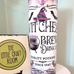Peut inclure: Un gobelet blanc avec un dessus violet et argenté, avec le texte "Witches Brew Drink Co." et des illustrations d'un chapeau de sorcière, de chauves-souris et d'un chaudron. La conception comprend les mots "Quality Potions Since 1543".