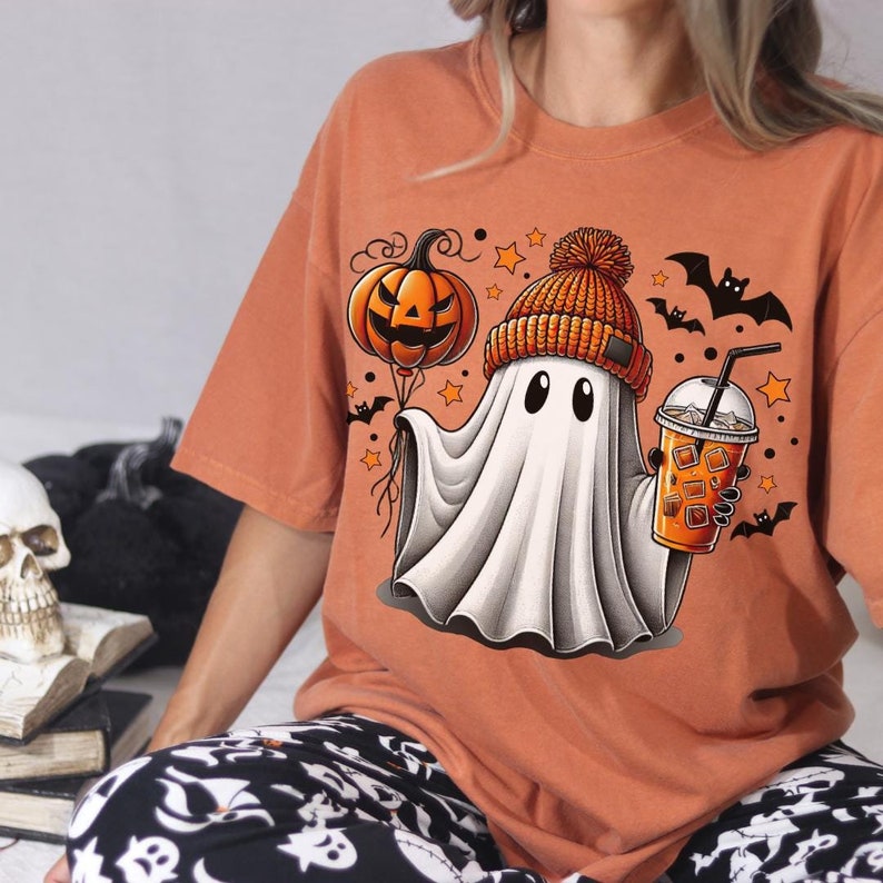 Cute ghost with iced coffee and a jack-o-lantern balloon. Designed by Phrase Fair