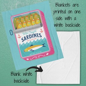 May include: A blue and pink illustrated can of sardines with the text "Wild Caught Sardines in Olive Oil" and "Net Wt. 3.75 oz". The can is on a light blue background with a white backside.