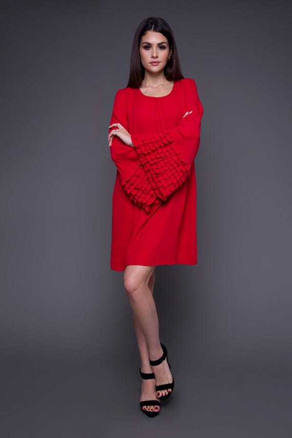 A short red dress with bell sleeves decorated with pleats. A Polish product, original with handmade elements.